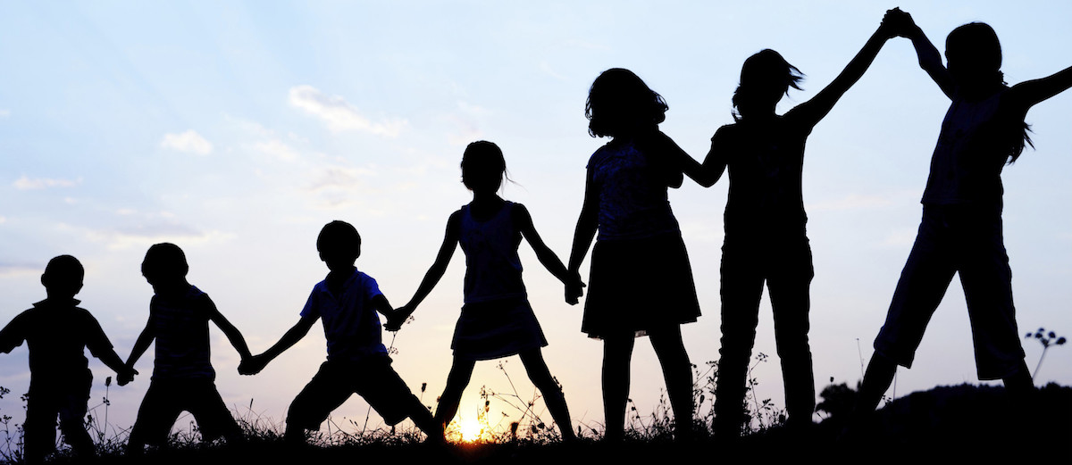 Silhouette, group of happy children playing on meadow, sunset, summertime